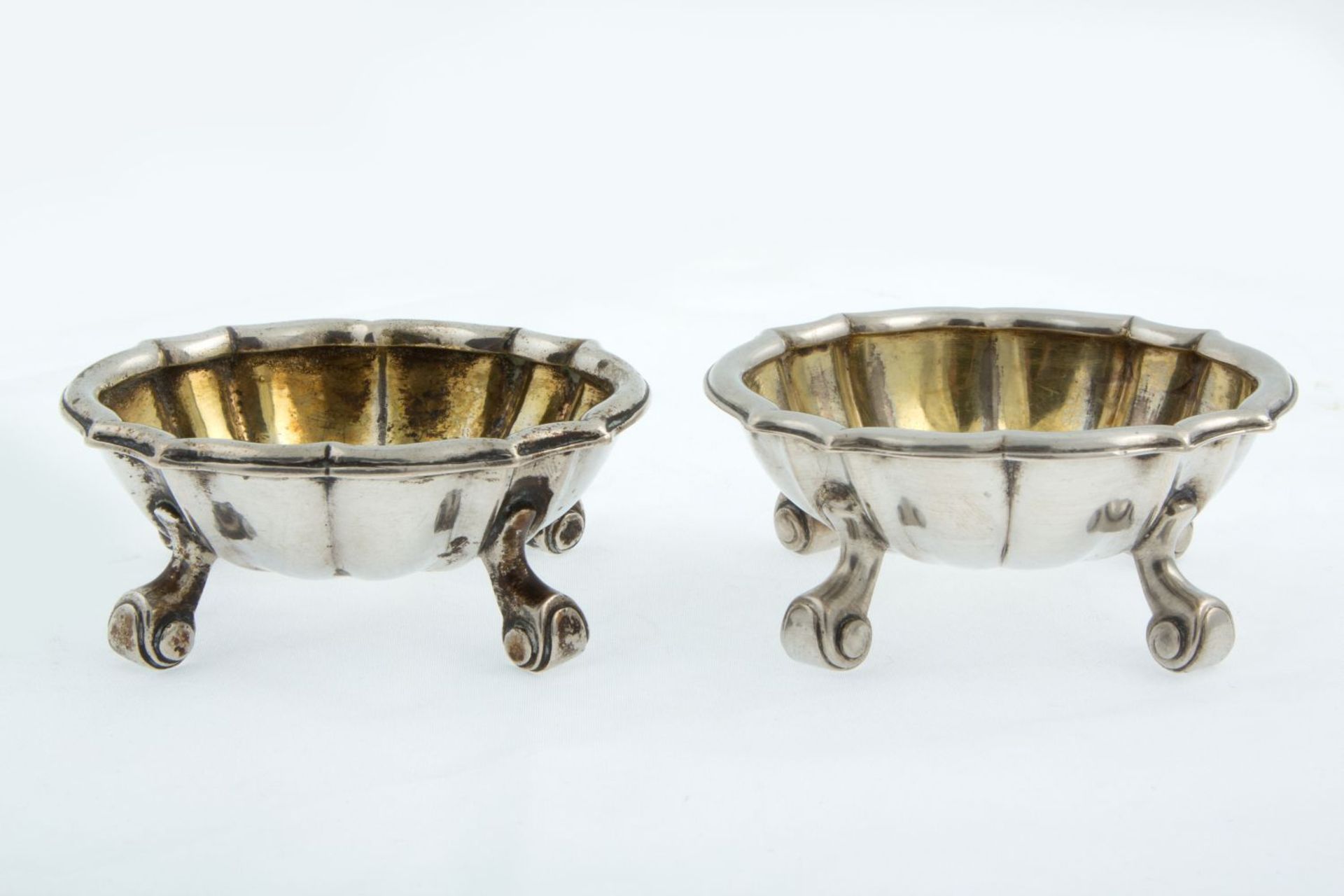 Ein Paar Gewürzschälchen Silber 12-lötig, innen vergoldet. Ovale Form mit passigem Rand auf 4 Volute