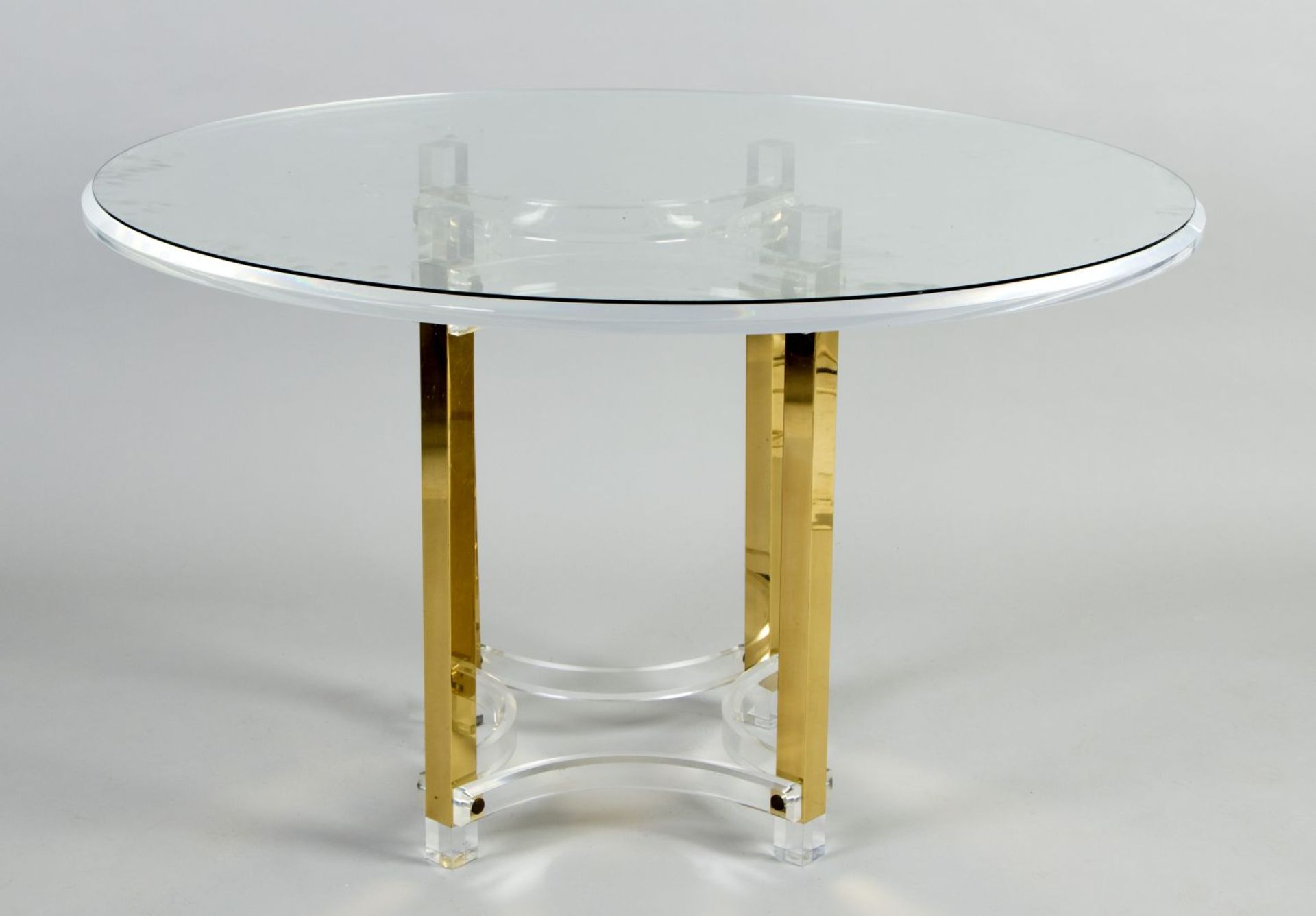 Tisch Acrylglas und Messing. Vierkantgestell mit Fußverstrebung. Runde Platte. H. 74 cm. D. 120 cm. 