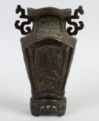 Vase Bronze. 2 seitliche Handhaben. Auf 4 Füßchen stehend. Auf der Wandung Kartuschen mit figürliche