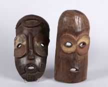 Zwei Masken Holz, geschnitzt. Braune und weiße Farbpigmente. Wohl BEMBE, D.R. Kongo. H. bis 37,5 cm.