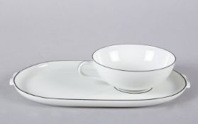 Teetasse auf großer Untertasse Schwarzer Rand. Geprägtes Rautenschild. Grüne Manufakturmarke. Nymphe