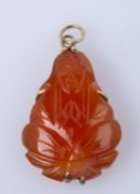 Anhänger Karneol. Montierung Silber, vergoldet. In Form eines Buddhas. H. 3,5 cm. Ca. 8 g. Best.