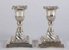 Ein Paar Kerzenleuchter, 1-flammig Sterlingsilber. Vasenförmige Tülle auf quadratischem Fuß. Firmens