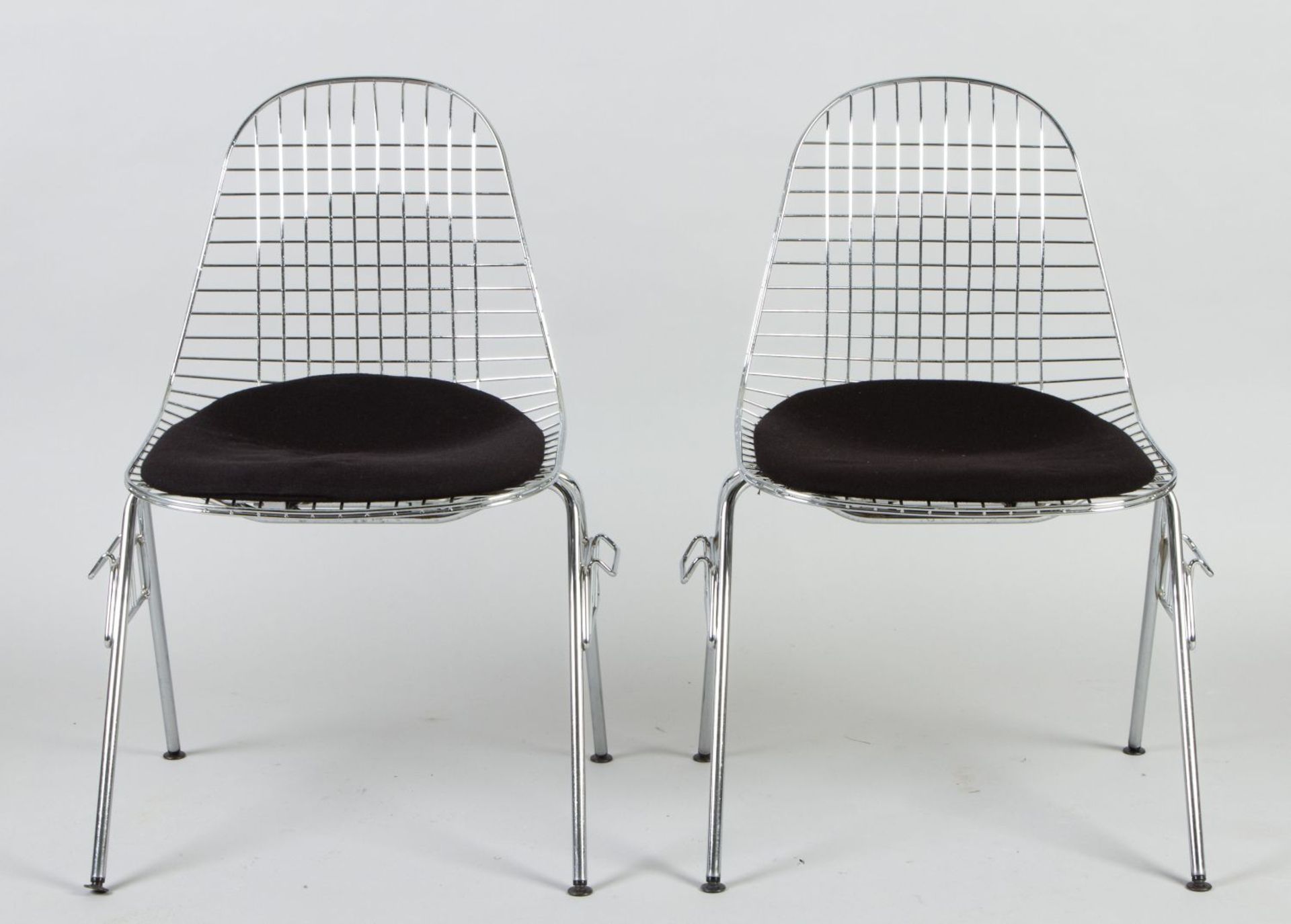 Ein Paar Wire Chairs DRX Verchromtes Metallgestell. Sitzauflage mit schwarzem Stoffbezug. Stapelbar.