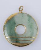 Jade-Anhänger Runde Jadescheibe mit zentraler Öffnung. Fassung aus Gelbgold 333 (geprüft). D. 3,5 cm