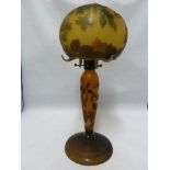 A cameo glass table lamp and cover, the domed glass shade on glass baluster stem cased in green
