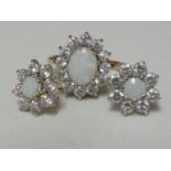 A light opal ring and earring set, the opals encircled by CZ stones, the ring of 9ct yellow gold,