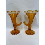 Bohemian - a pair of amber cased glass vases in cornucopia form, the amber casing cut through to