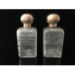A pair of cut glass and French white metal perfume flasks, of square section, cut with foliate