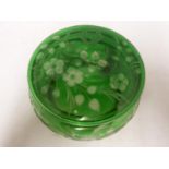 Stevens and Williams - an intaglio cut glass powder bowl cover of green overlay cut through to