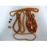 Various items of amber jewellery comprising: two graduated round bead necklaces with screw