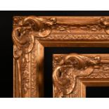20th Century English school. A Gilt Composition frame with swept and pierced centres and corners,