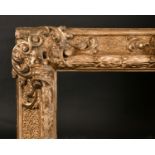 19th Century Italian School. An Elaborate Carved Giltwood Florentine Frame, with swept centres and