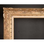 19th Century French School. A Carved Giltwood Frame, with swept centres and corners, and a fabric