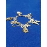 9ct gold charm bracelet with 7 charms weighing 21.8grams..