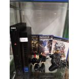 Shelf of PlayStation 2 console with games etc.