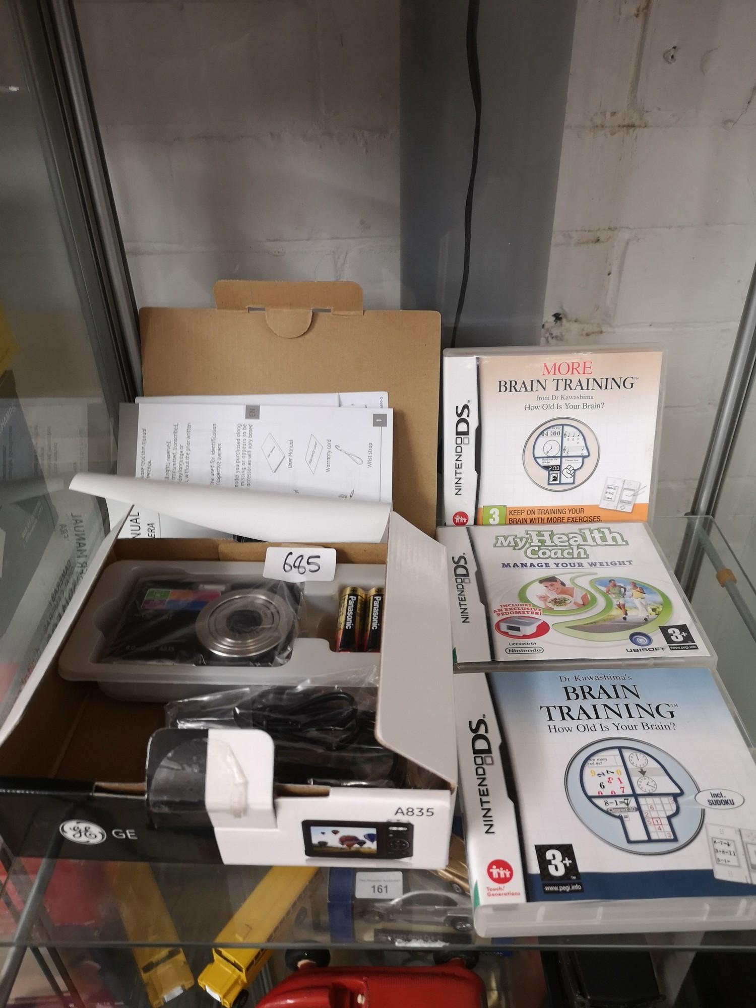 Camera boxed together with nintendo ds games.