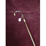 Antique walking stick with yellow metal mounts.