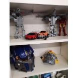 2 transformers toy masks together with shelf of toys.