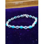 Silver hall marked bracelet set in turquoise and blue topaz stones .
