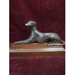 Bronze dog ornament sat up On a base.