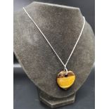 Large silver chain set in tiger eye style pendant.