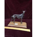 Bronze style dog Figure on a wooden plinth.