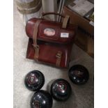 Set of bowling bowls with fitted leather bag .