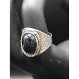 Silver ornate ring with black stone setting.