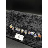 Heavy silver and enamel charm bracelet to include balmoral castle charm etc .