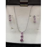 Silver necklace and earring set in pink stones.