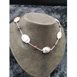 Silver statement necklace set in red stones.