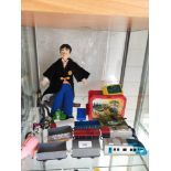 Shelf of toy s includes harry potter doll , train vehicles etc .