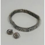 Decorative silver stud earrings and decorative silver metal bracelet.