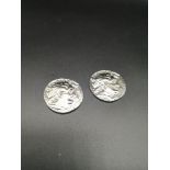 2 ornate white metal coins.