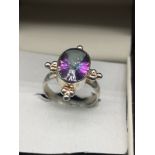 Ornate silver ring set with purple stone.