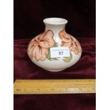 Moorcroft vase with white back ground with hibicus pattern.