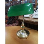 Brass desk lamp with green shade.