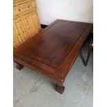 Oriental rosewood coffee table with carved supports.
