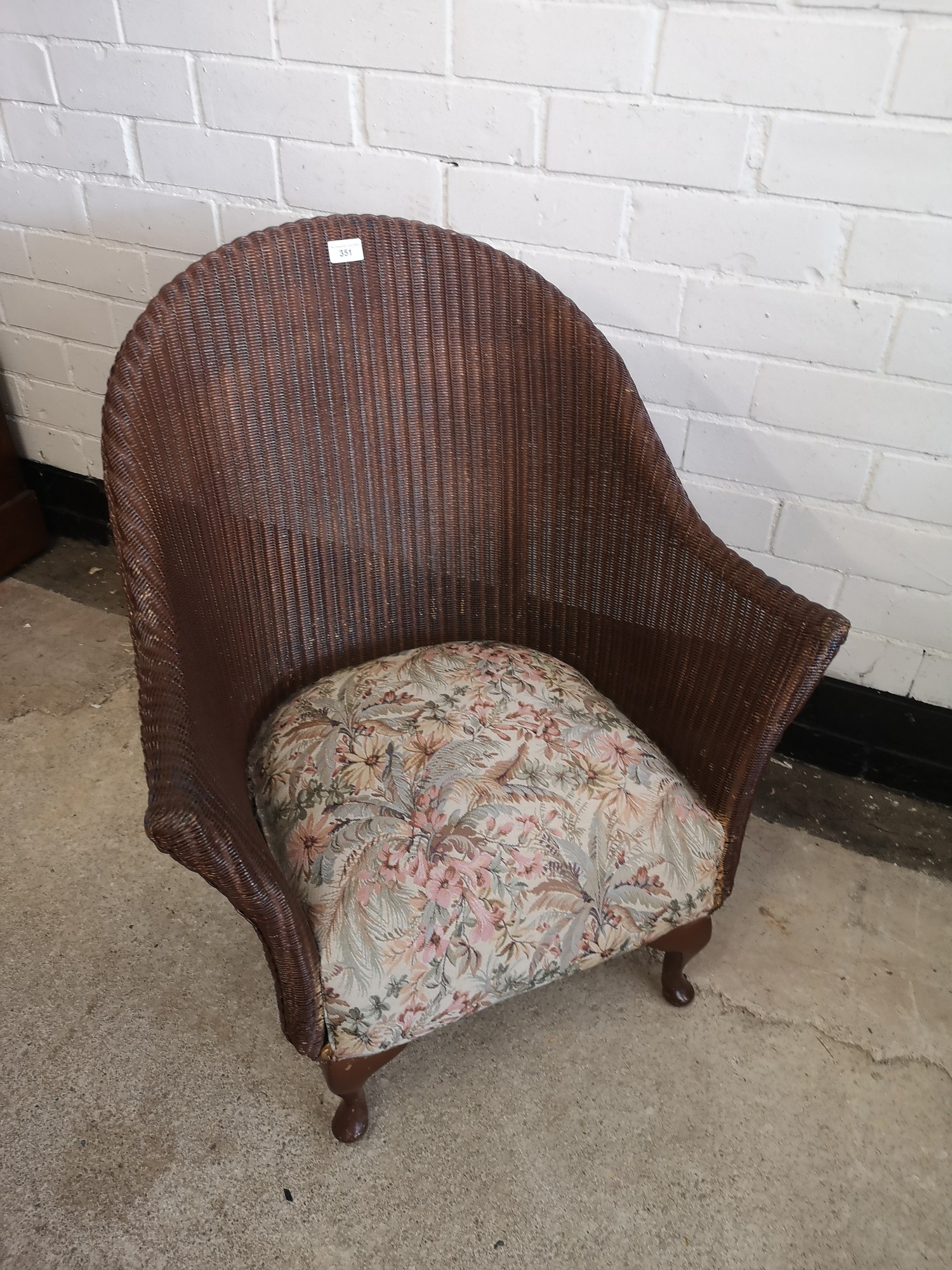Lloyd loom style wicker chair with upholstery.