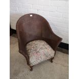 Lloyd loom style wicker chair with upholstery.