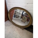 Large victorian oval mirror with carved design.