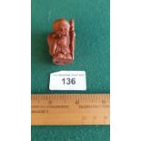 Carved fruit wood netsuke of Oriental monk with signature to base.