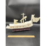 Large oriental carved boat on a wooden stand with flags etc.