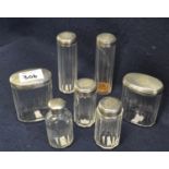 A group of assorted plain silver topped glass dressing table jars with pillar cut bodies. (7) (B.