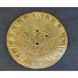 Small brass sun dial bearing date 1672, 15cm diameter approx. (B.P. 21% + VAT) Rather misshapen