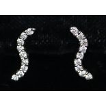 9ct white gold diamond set earrings in wave design. Weight approx 1.3 grams. (B.P. 21% + VAT)