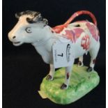 19th Century Swansea Cambrian pottery cow creamer having pink lustre decoration standing on a