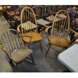 A pair of elm and beech Ercol spindle and hoop back armchairs with gold stickers, together with