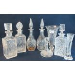 A collection of mainly cut glass decanters with stoppers of varying forms including; mallet and